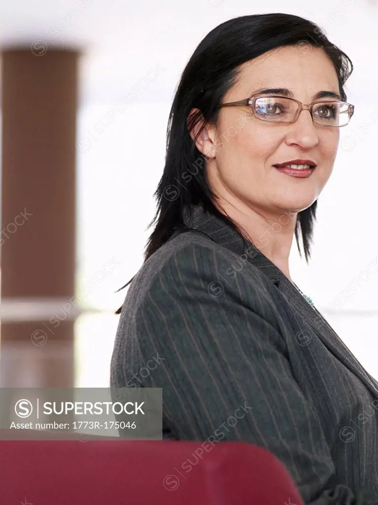 Mature businesswoman wearing spectacles, smiling, portrait