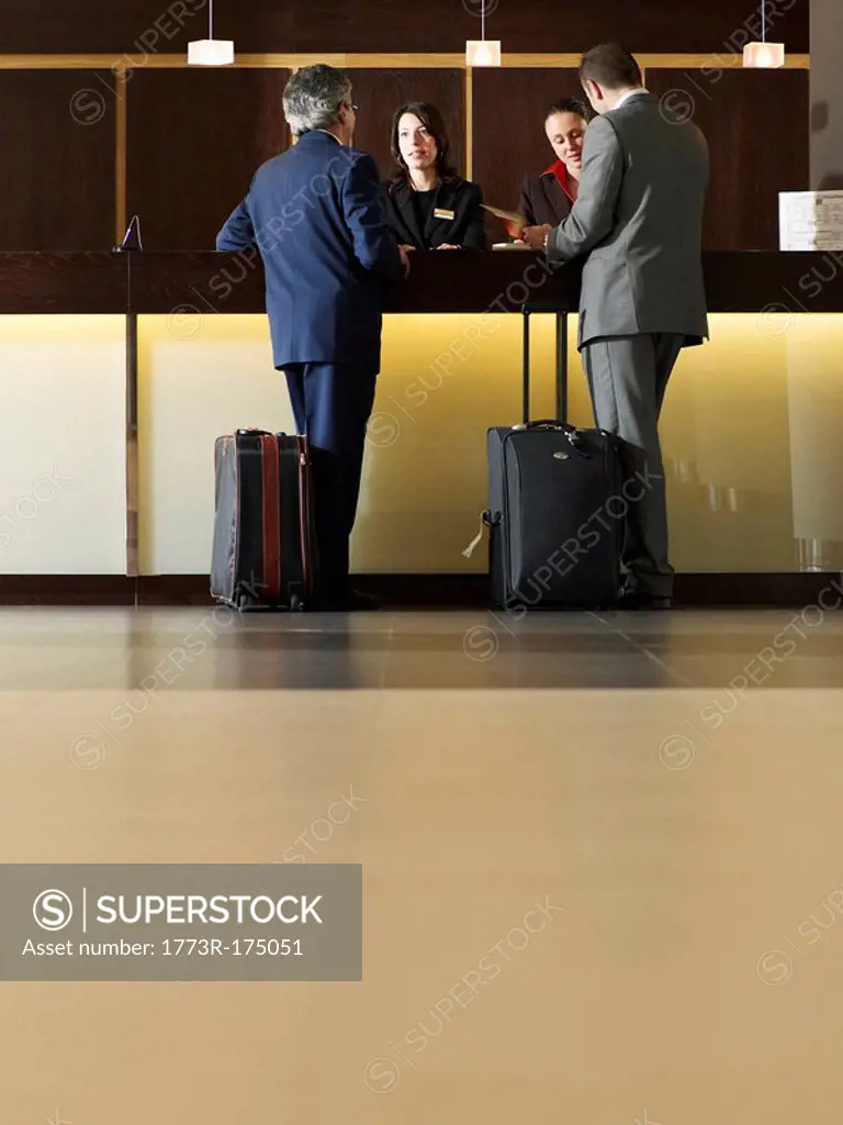Two businessmen standing at hotel reception