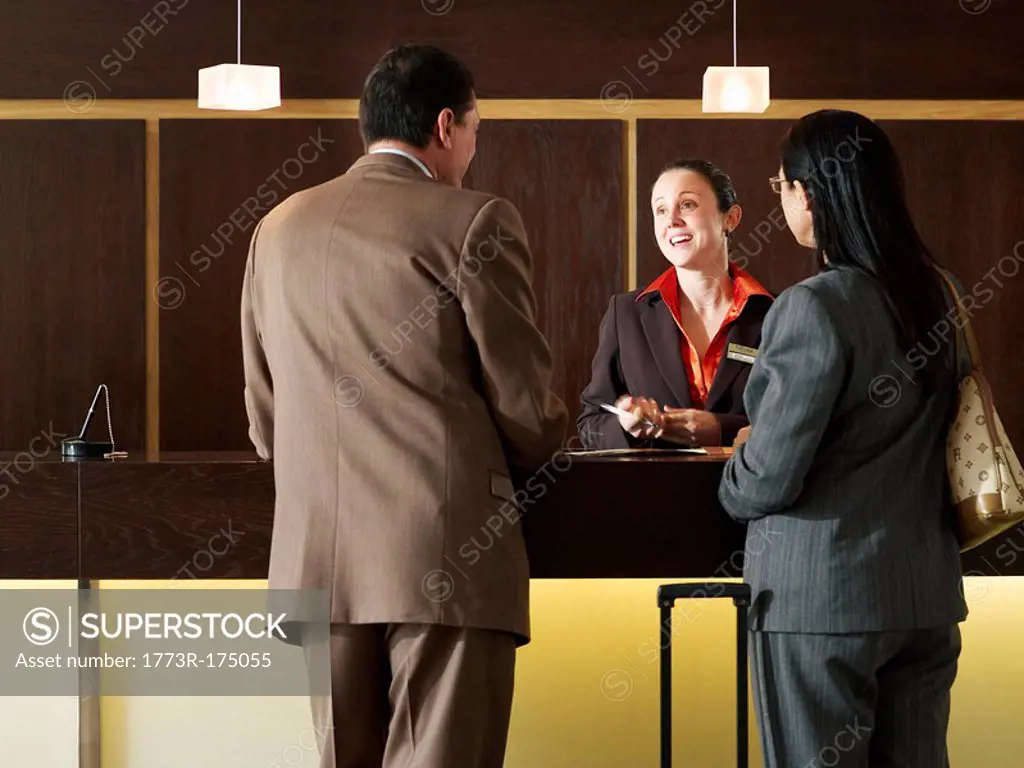 Businessman and woman at hotel reception, rear view