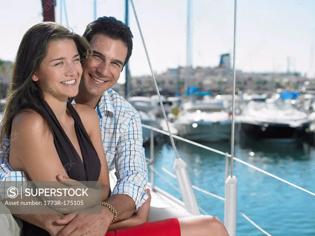 Young couple relaxing on yacht, smiling