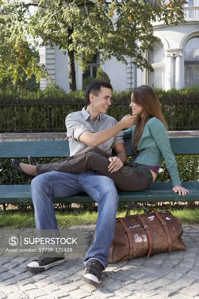 Couple sitting on a bench smiling