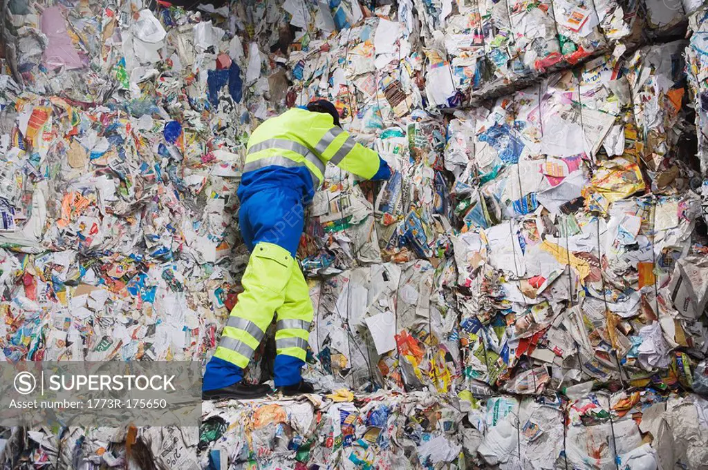 Man leaning on wall of recycling