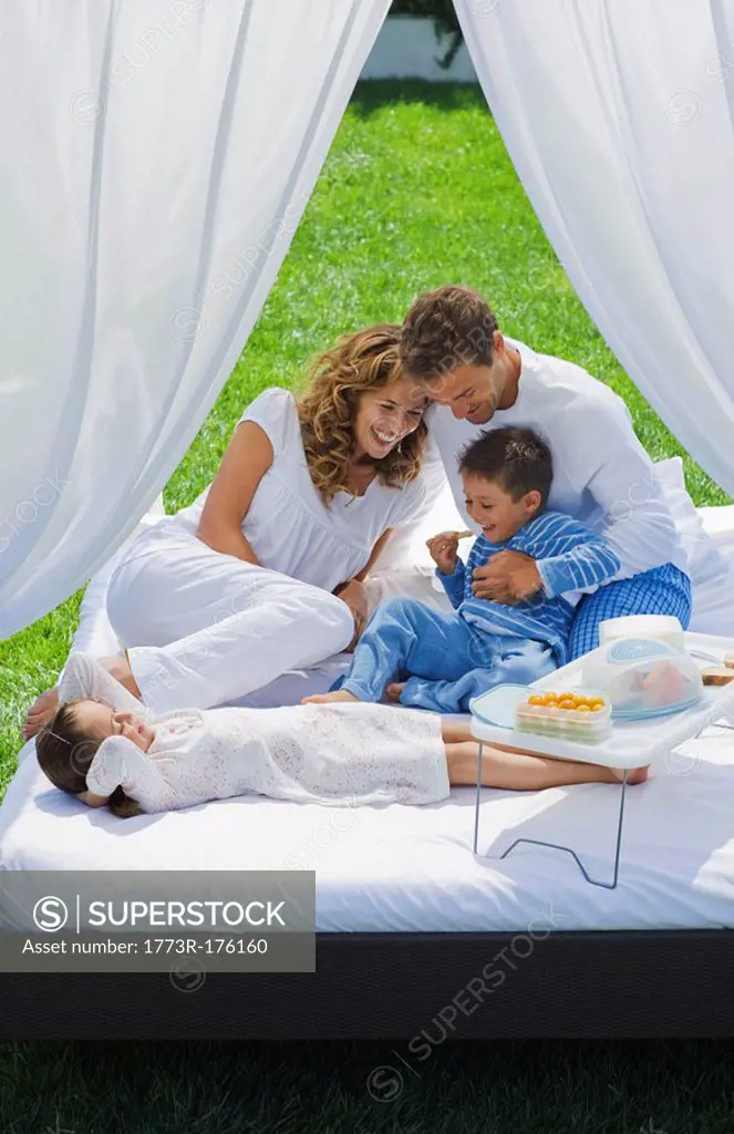 Family having breakfast on bed in garden