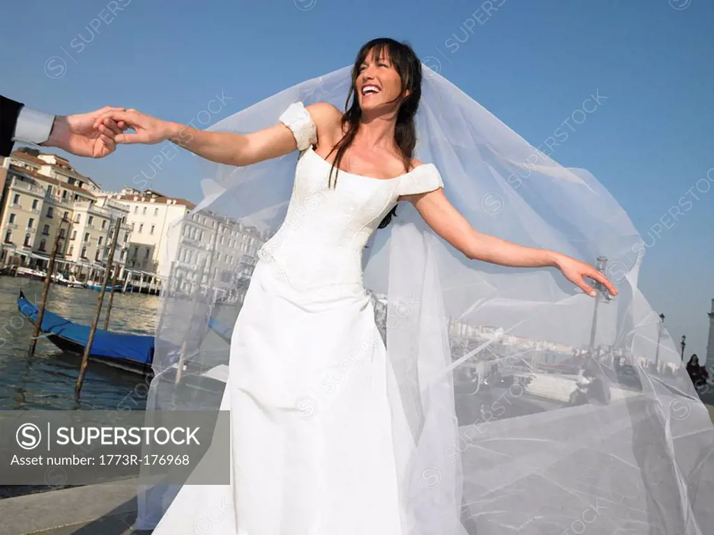 Italy, Venice, bride holding man´s hand, smiling