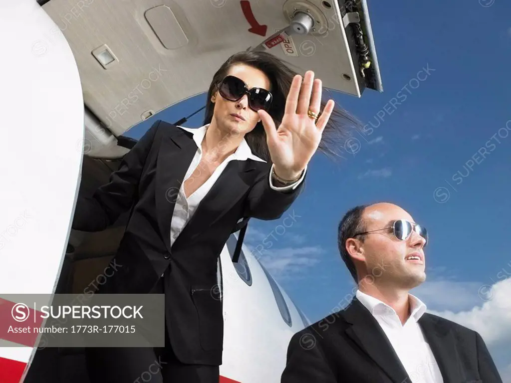 Offensive businesswoman and businessman exiting private jet