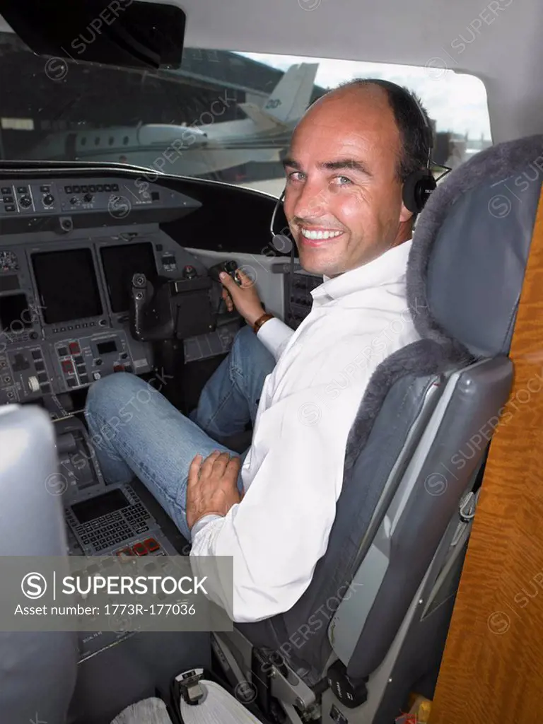 Male pilot in cockpit of private jet