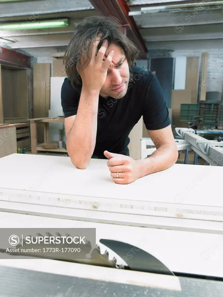 Pensive carpenter working in his workshop