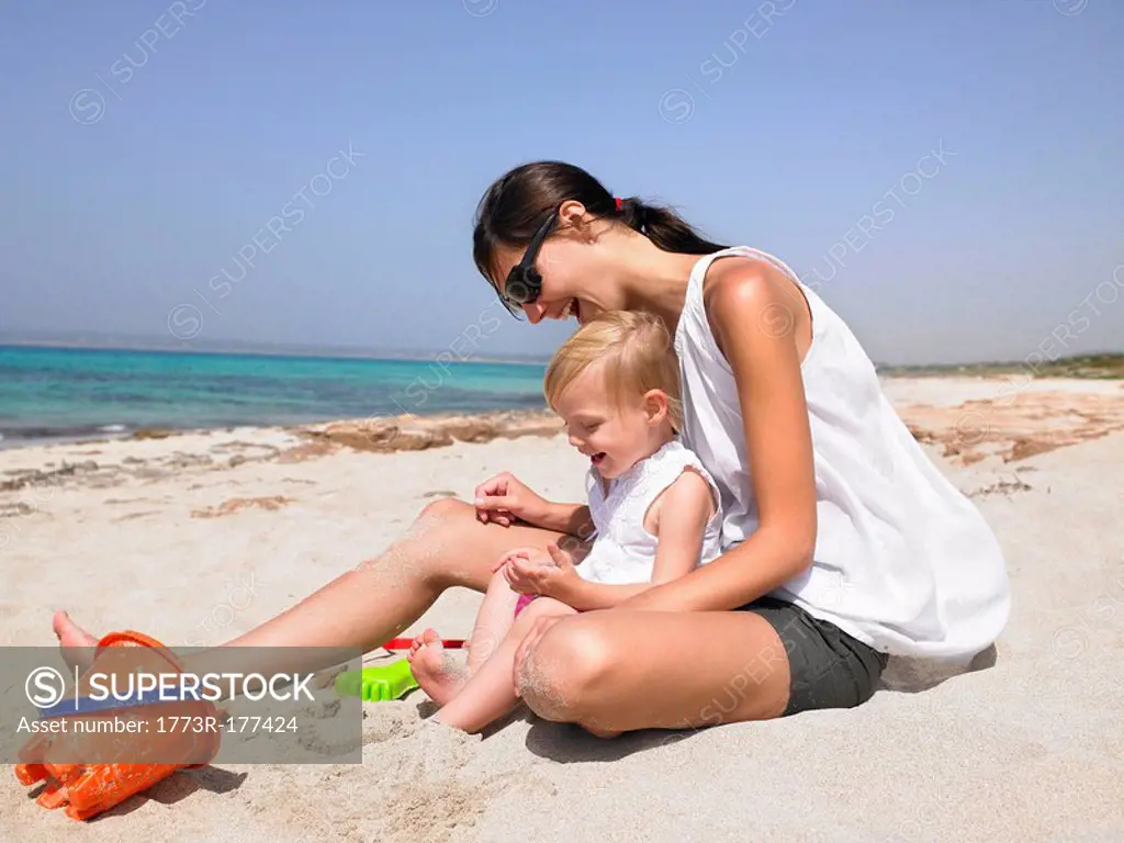 Woman and young boy at the beach playing and smiling