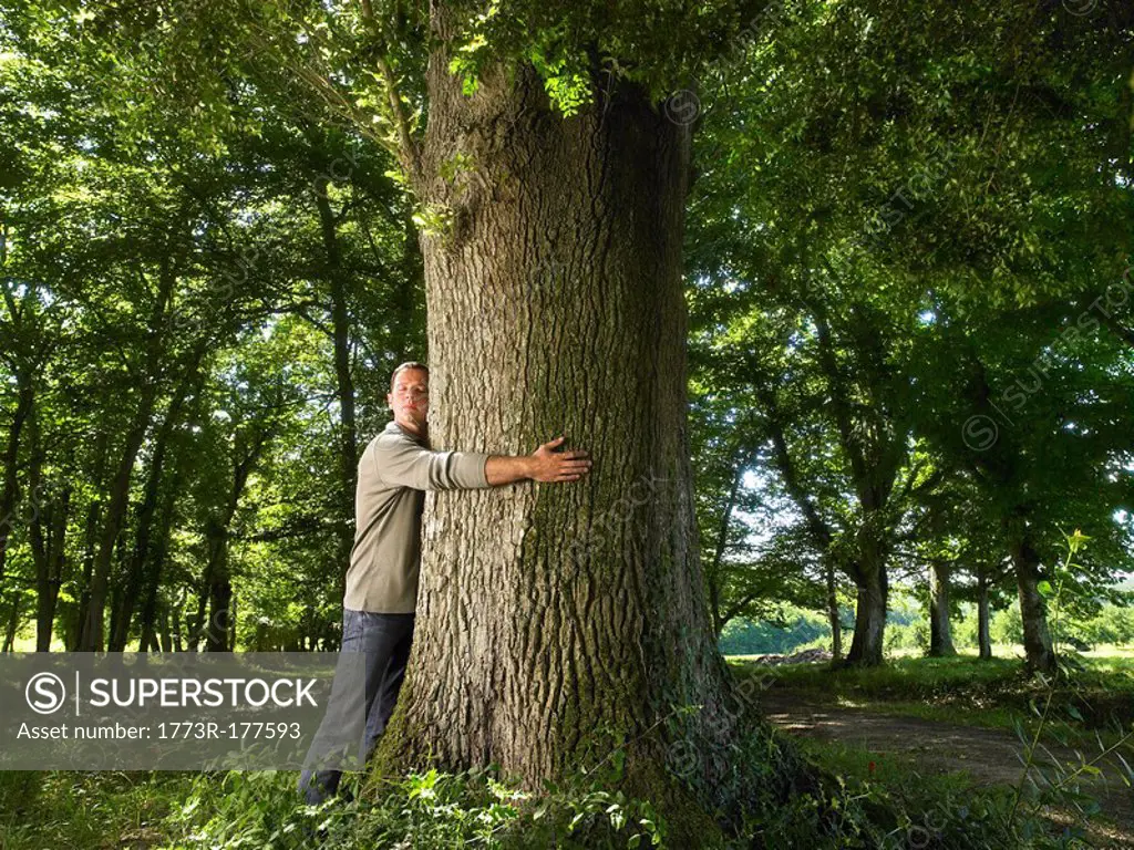 Man embracing a tree trunk