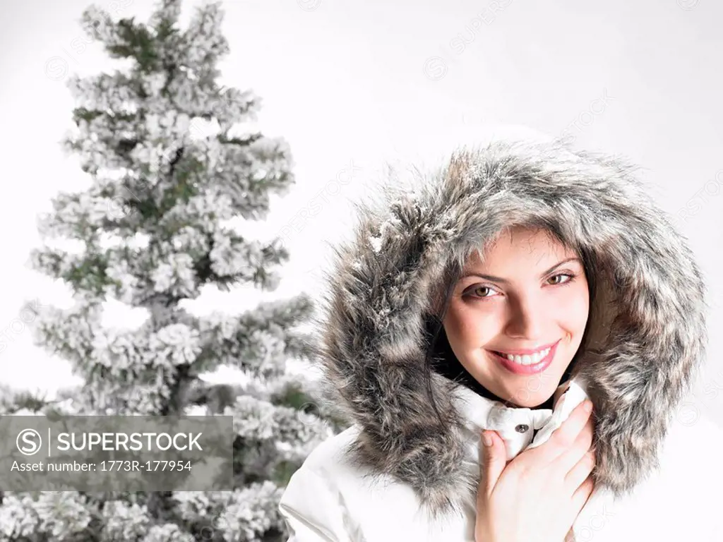 Woman next to a fir_tree, smiling
