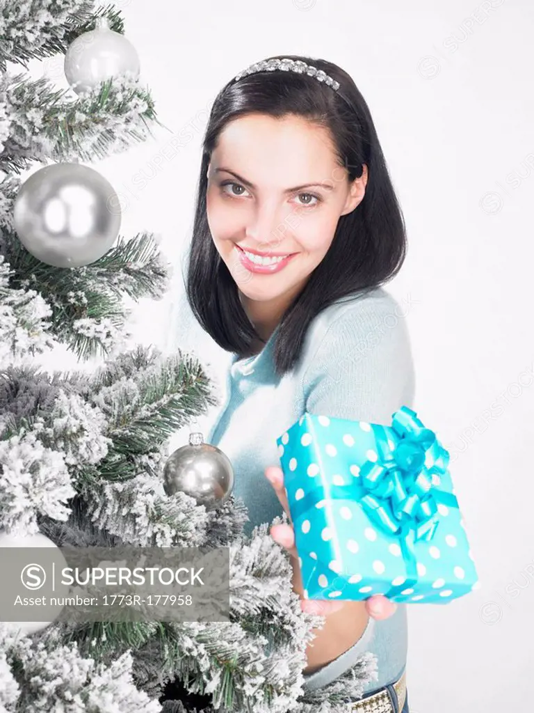 Woman next to a fir_tree, with present