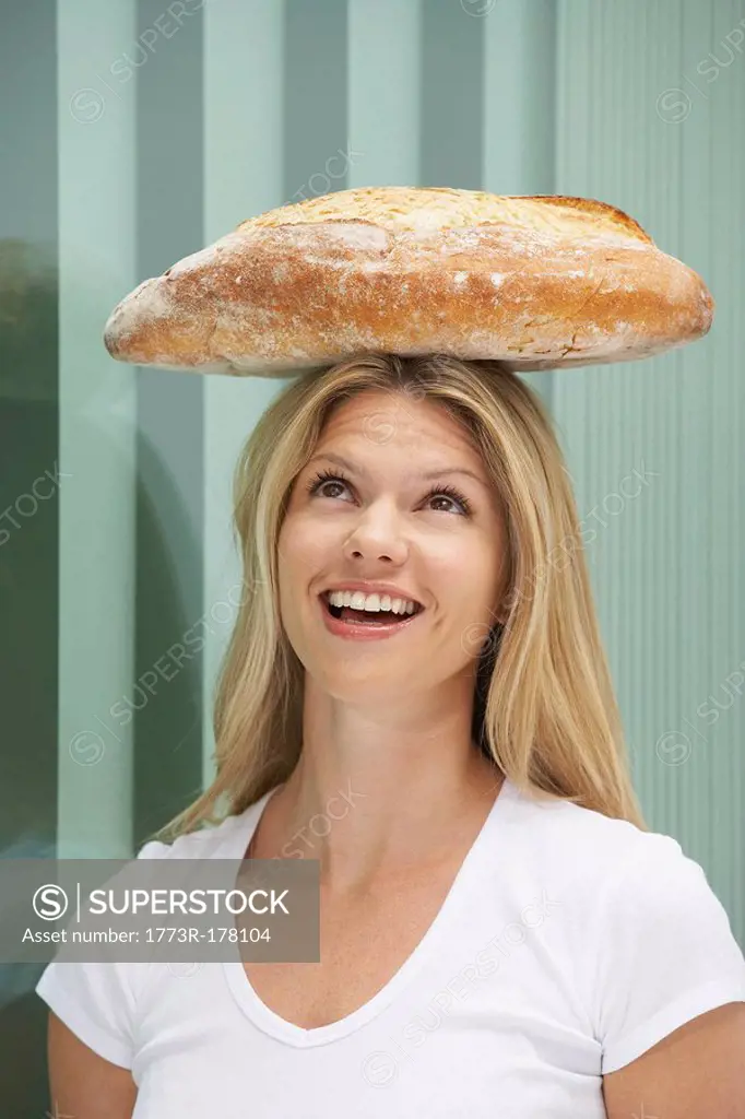 Young woman with loaf of bread on head