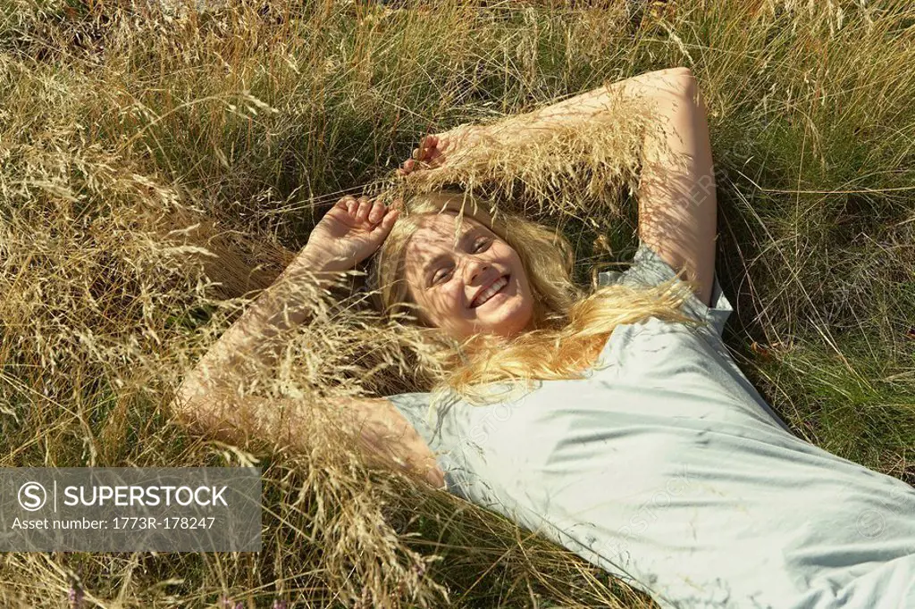Young woman lying in long grass