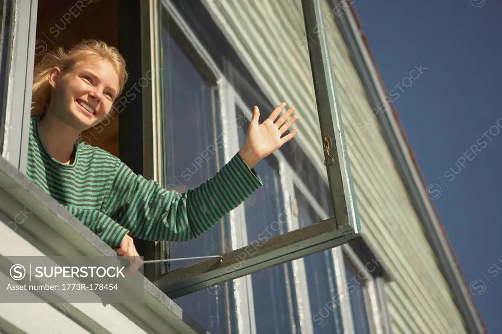Young woman appearing from window