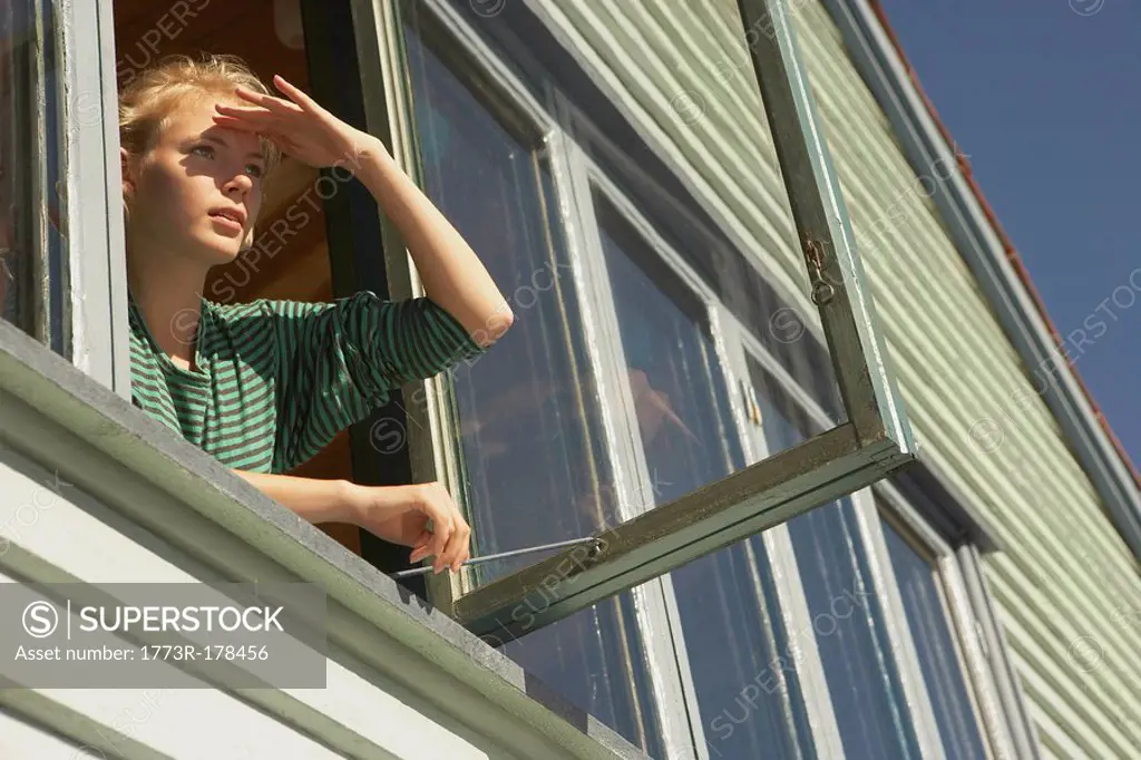 Young woman appearing from window