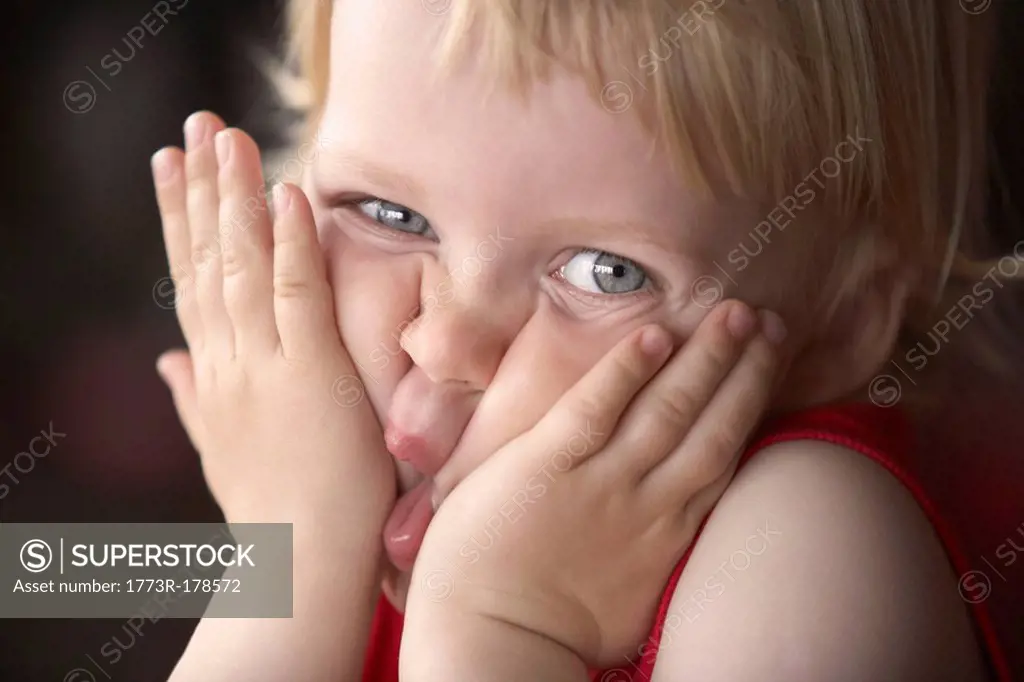 Boy squeezing face, looking at camera