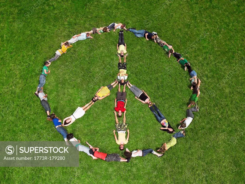 Group lying on grass in a peace sign formation