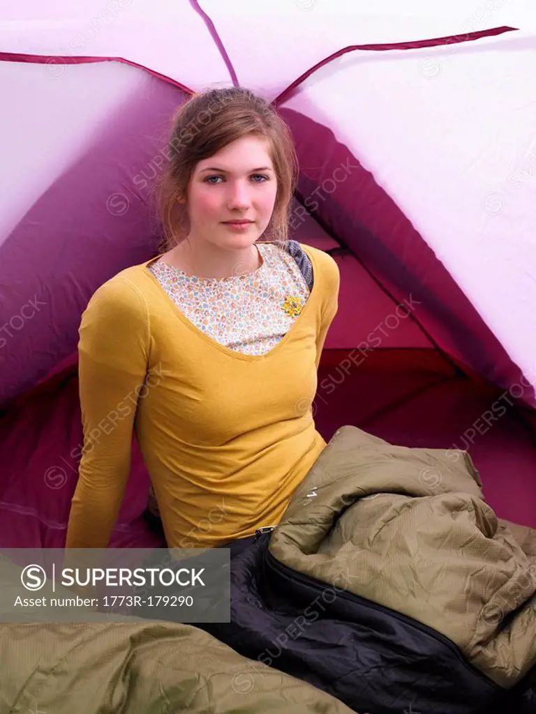 Girl sitting in sleeping bag in pink tent
