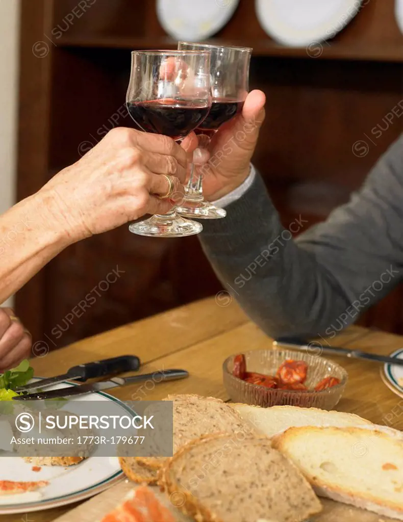 Senior couple toasting each other with wine, close-up