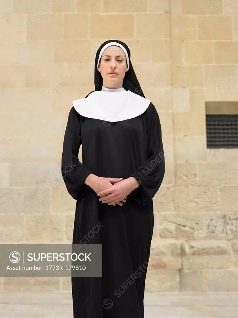 Portrait of nun clasping hands looking into camera, Alicante, Spain,