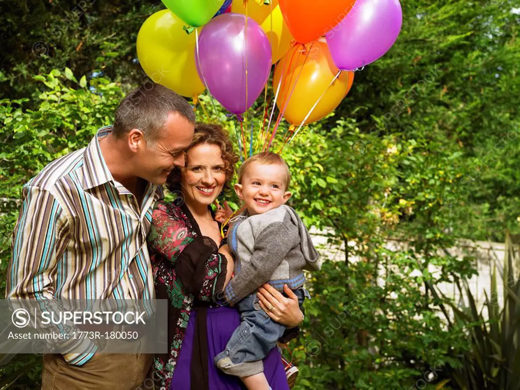 Mother, father and baby with balloons