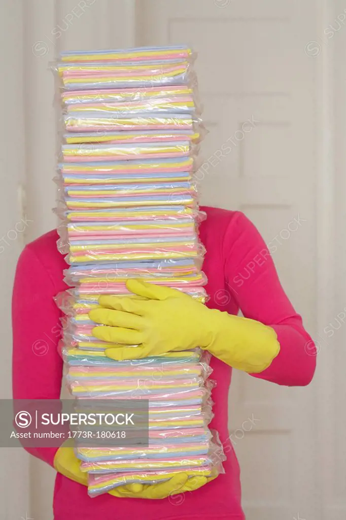 Young woman carrying stack of cleaning cloths