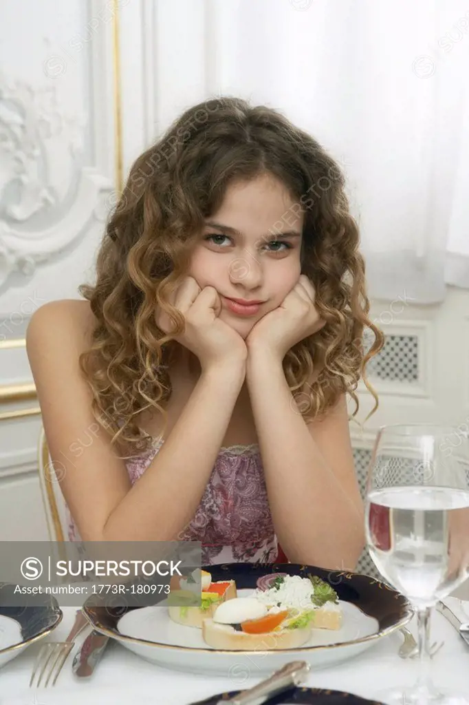 Girl 9-11 leaning on dinner table, portrait