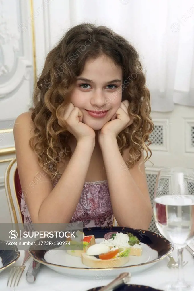 Girl 9-11 leaning on dinner table, portrait