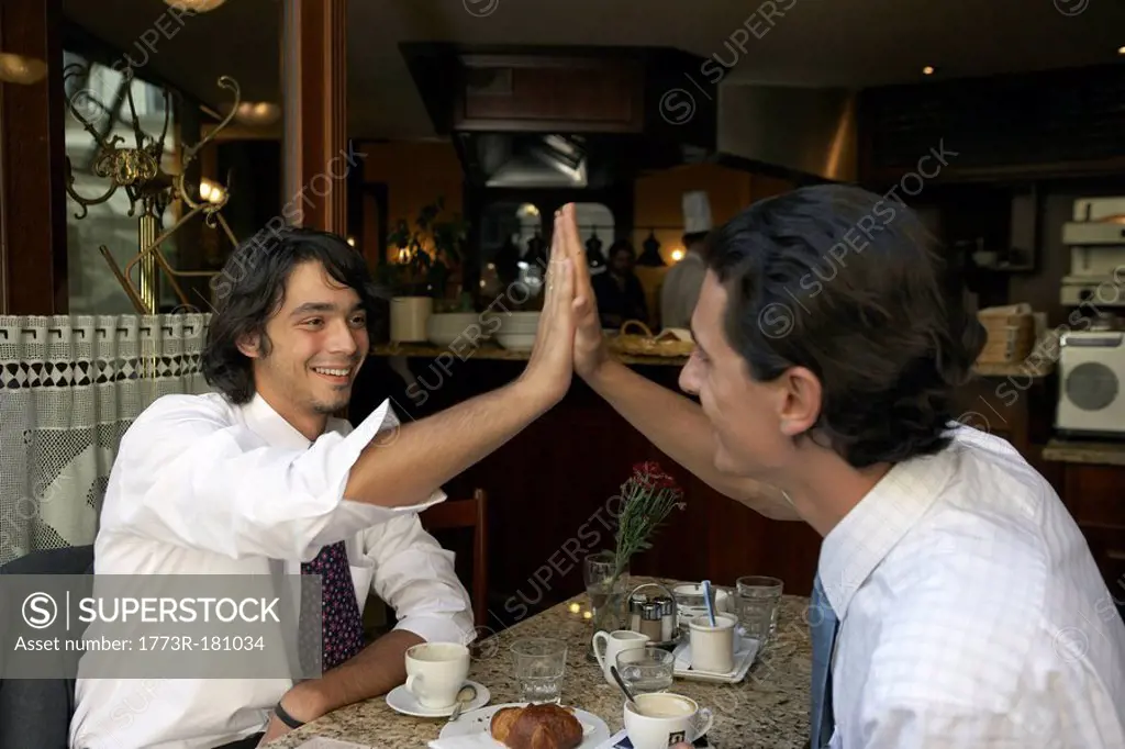 Businessmen giving a high five to each other
