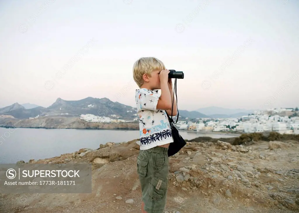Young boy using binoculars in Greece