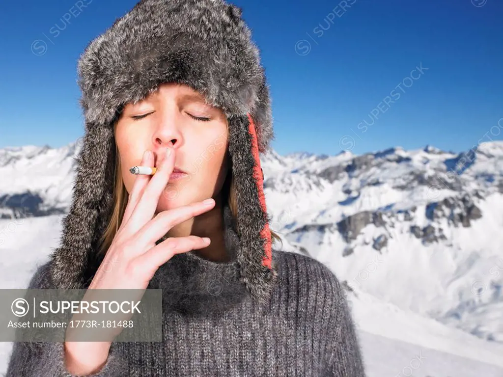 Young woman in hat smoking