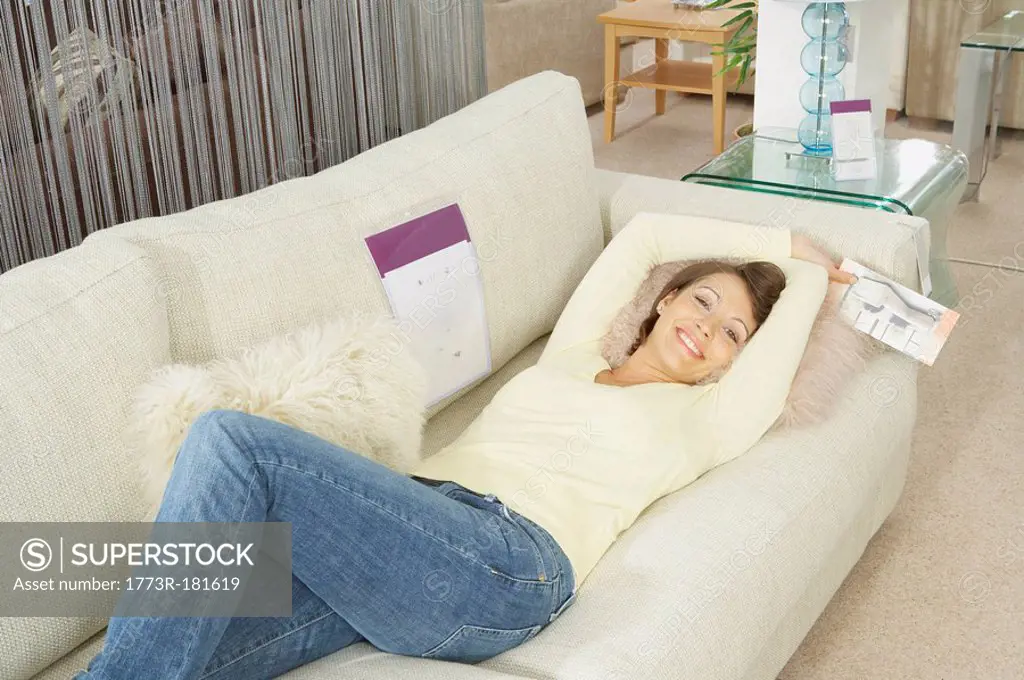 Woman lying on sofa in furniture store