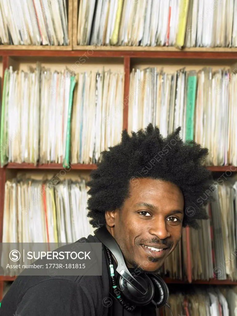 Disc jockey in front of shelves of records