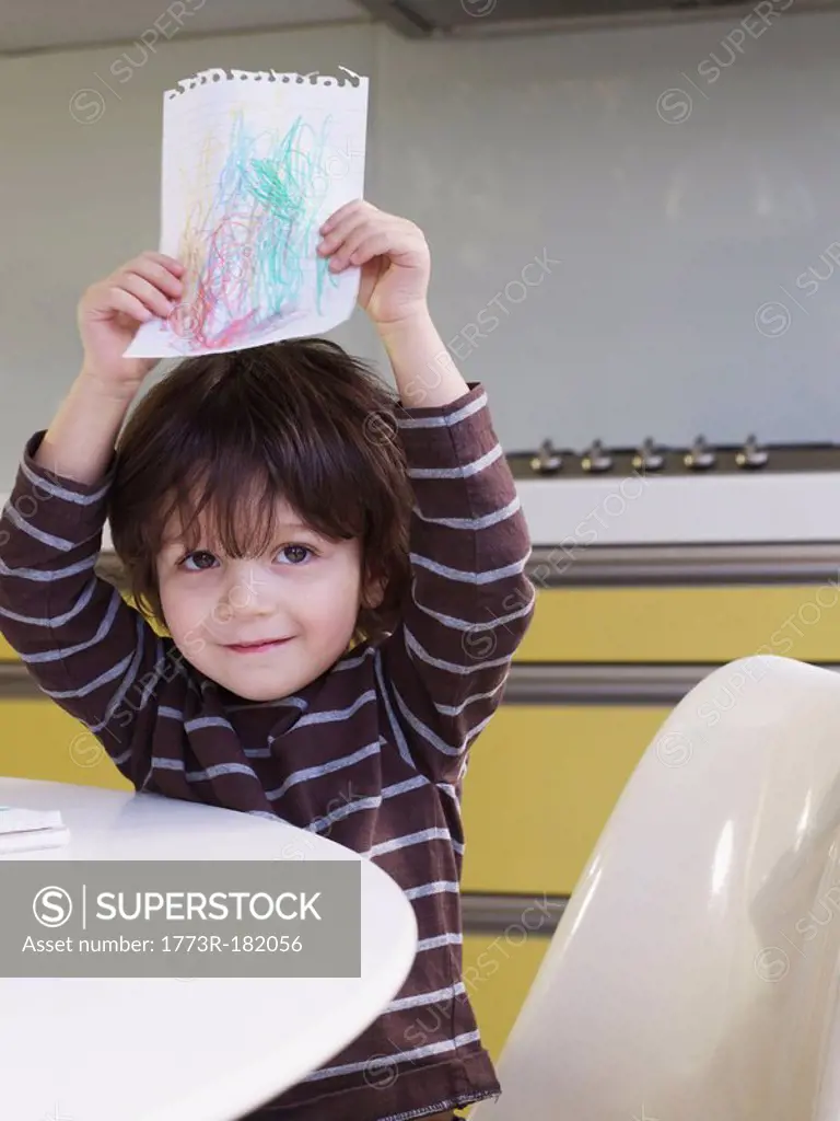 Boy holding up drawing