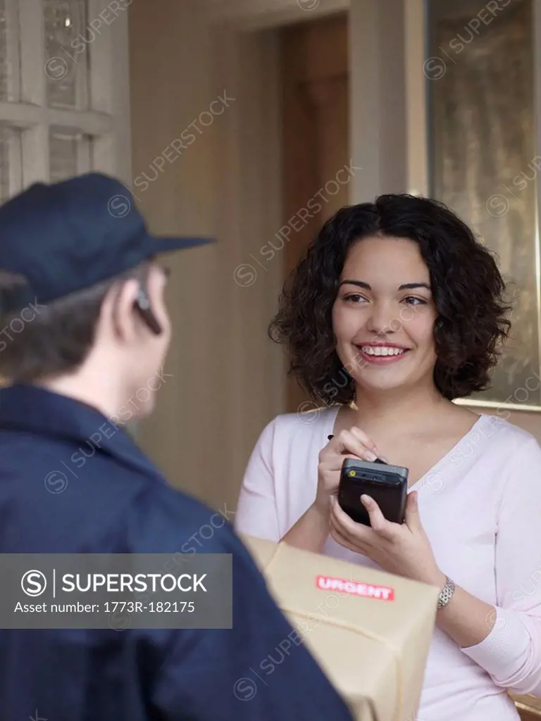 Woman signing for package with courier