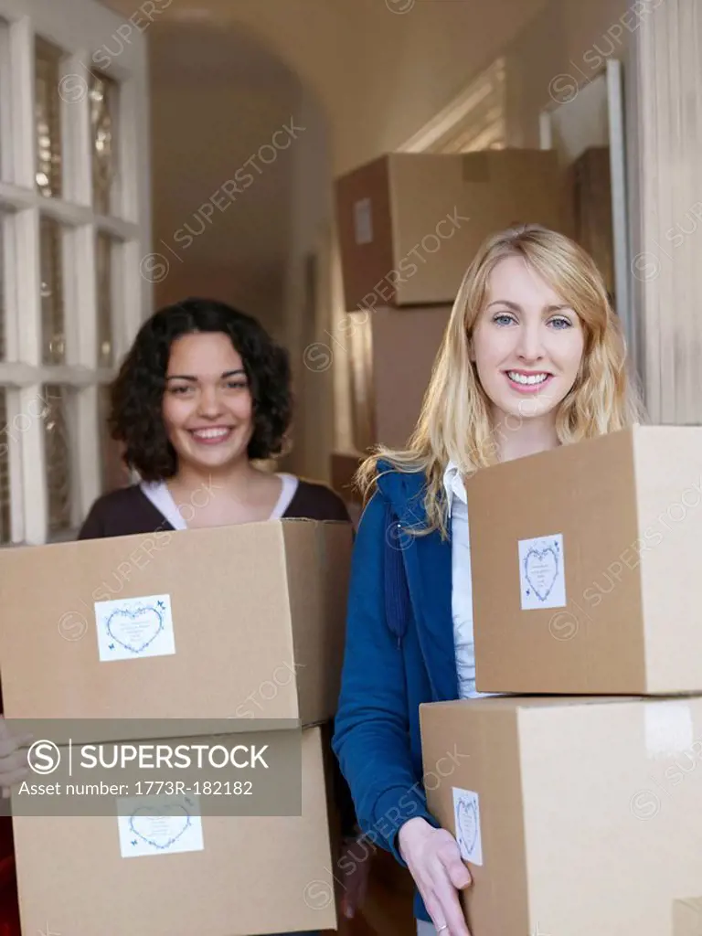 Women with boxes of goods in doorway