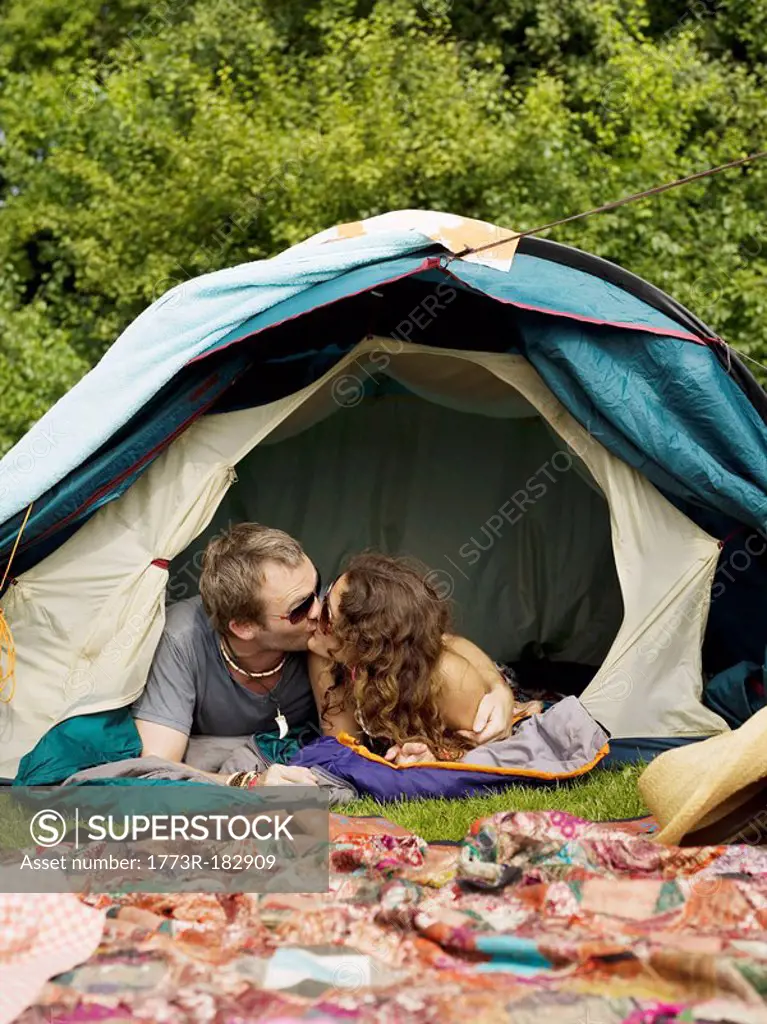 Man and woman lying inside tent