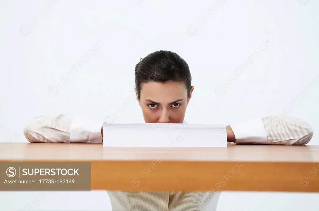 Portrait of woman looking over paper
