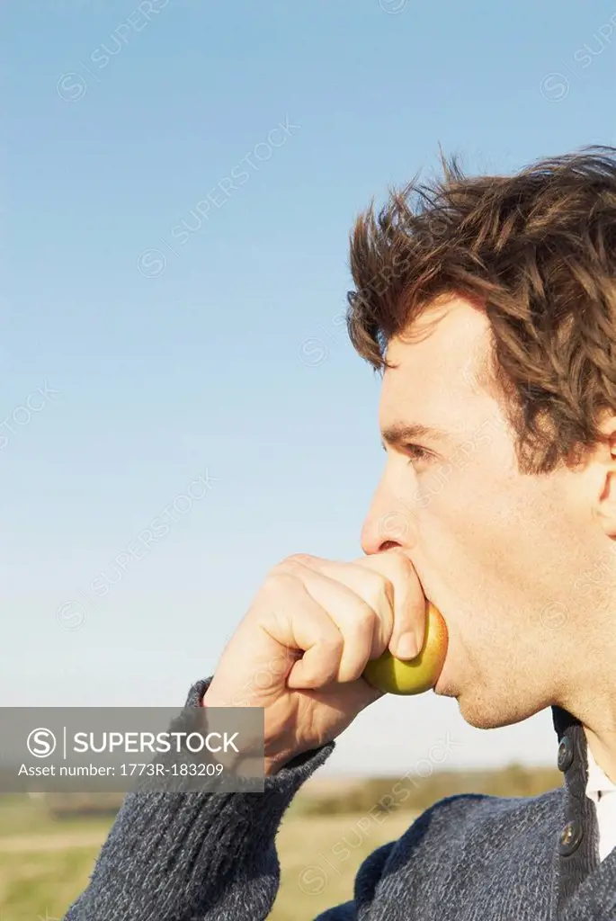 Man eating apple in countryside