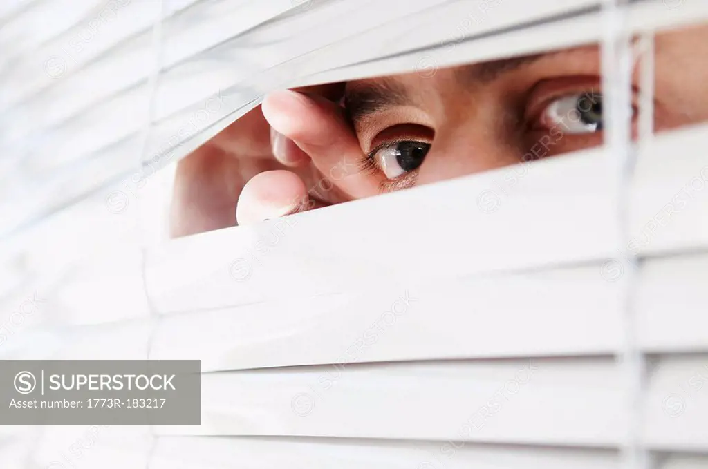 Man looking through office blinds