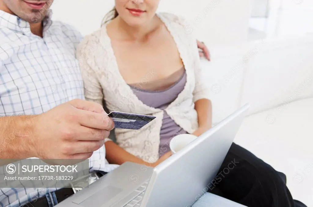 Couple on sofa, making purchase online