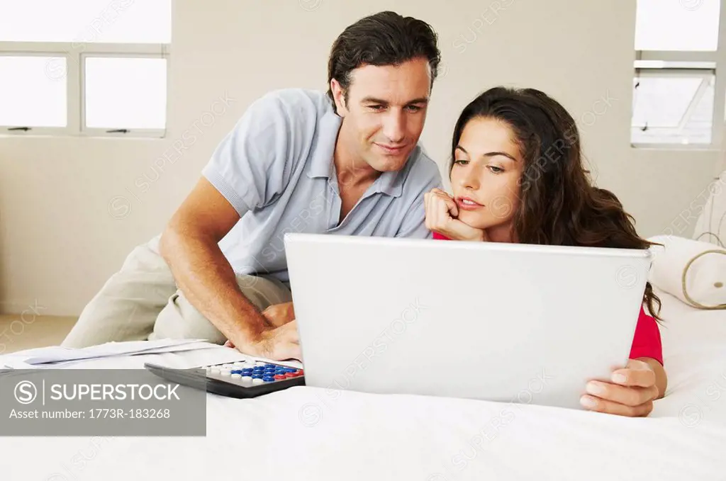 Couple discussing bills on bed