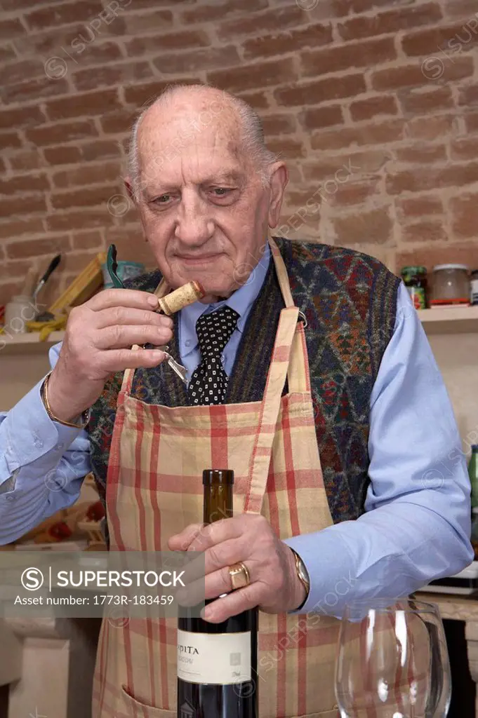 Senior man sniffing wine cork