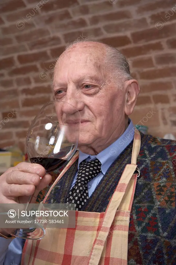 Senior man smelling red wine
