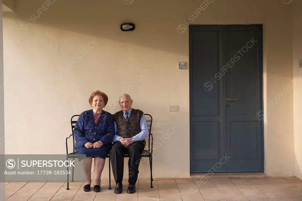 Senior couple on bench outdoors, portrait