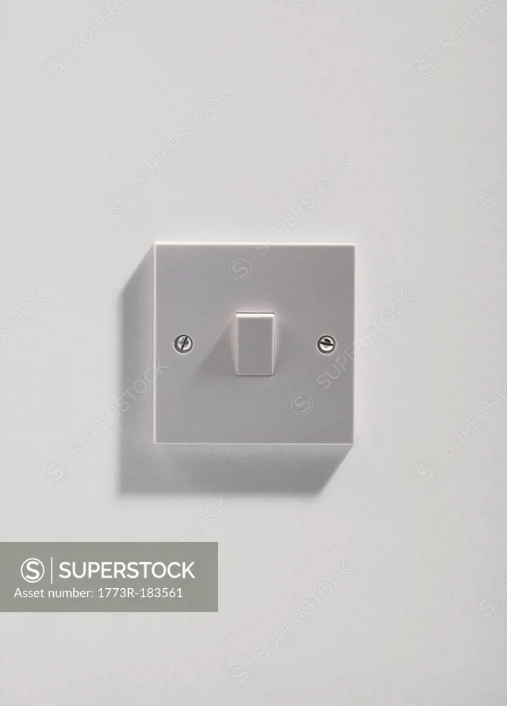 Electrical light switch on white wall