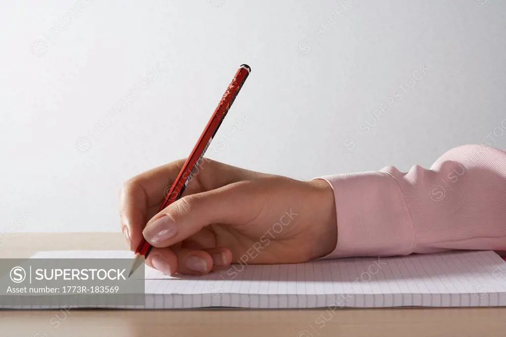Woman´s hand with a pencil on a pad