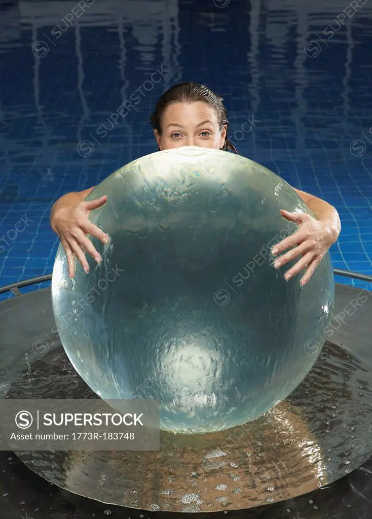 Woman with water globe in pool