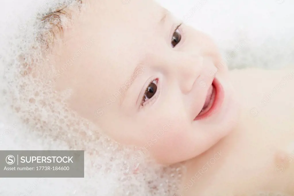 Baby boy laying in bubble bath