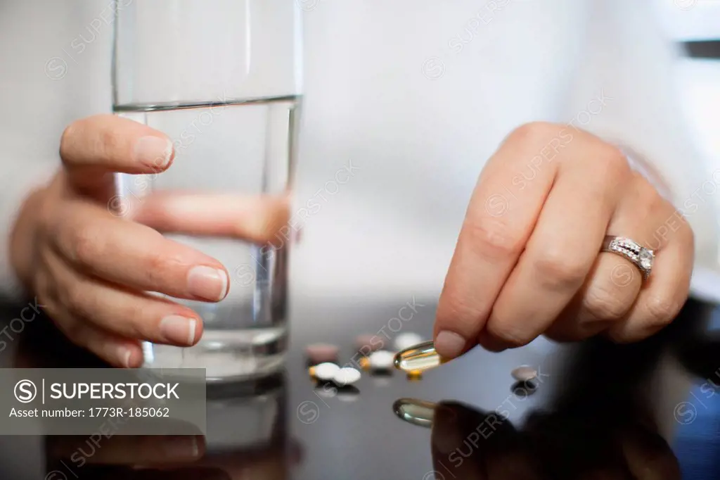 Close up of woman taking vitamins